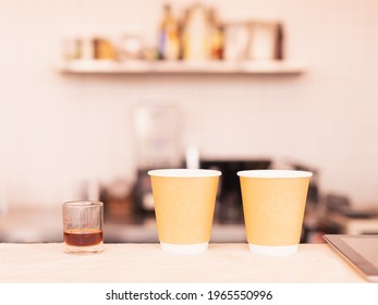 Two Takeaway Coffee Cups And Coffee Measure Cup Are Placing On Coffee Counter Bar. Barista Work At Food And Coffee Service Business.