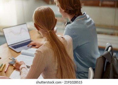 Two talented students working together on university project sitting in library. Back view - Powered by Shutterstock