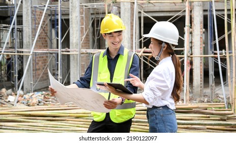 Two Talented Young Asian Male And Female Civil Engineer Discussing And Working Together At The Construction Site.