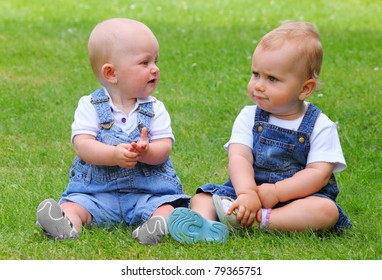 Two talking children on green meadow.