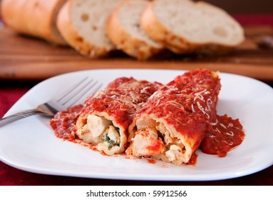 Two Tasty Stuffed Manicotti Shells Topped With Pasta Sauce And Italian Bread On The Side