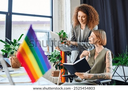 Two team members discuss creatively amid vibrant decor that promotes inclusivity.