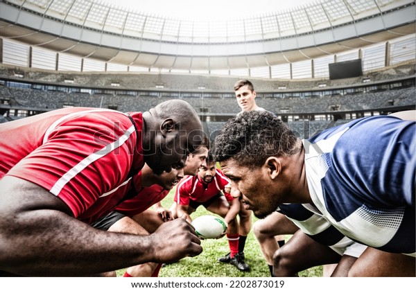 Two teams of multi-ethnic rugby players\
playing rugby at a sports stadium, wearing team strip, facing each\
other, one player holding a rugby ball. Sport and competition\
concept digital composite.