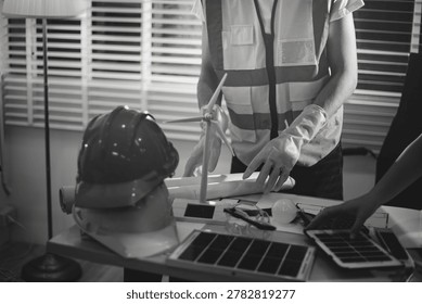 Two technicians inspect server racks in data center with tablet and fiber optic cable. Engineer and specialist discuss maintenance work in data center. Man and woman work together with safety equipmen