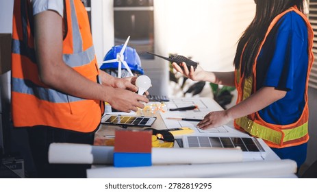 Two technicians inspect server racks in data center with tablet and fiber optic cable. Engineer and specialist discuss maintenance work in data center. Man and woman work together with safety equipmen