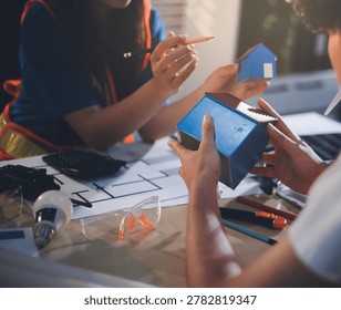 Two technicians inspect server racks in data center with tablet and fiber optic cable. Engineer and specialist discuss maintenance work in data center. Man and woman work together with safety equipmen