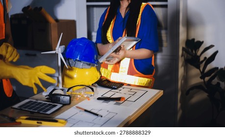 Two technicians inspect server racks in data center with tablet and fiber optic cable. Engineer and specialist discuss maintenance work in data center. Man and woman work together with safety equipmen