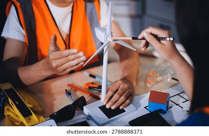 Two technicians inspect server racks in data center with tablet and fiber optic cable. Engineer and specialist discuss maintenance work in data center. Man and woman work together with safety equipmen