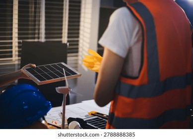 Two technicians inspect server racks in data center with tablet and fiber optic cable. Engineer and specialist discuss maintenance work in data center. Man and woman work together with safety equipmen