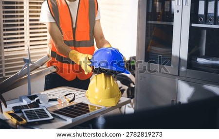 Two technicians inspect server racks in data center with tablet and fiber optic cable. Engineer and specialist discuss maintenance work in data center. Man and woman work together with safety equipmen