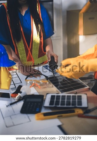 Two technicians inspect server racks in data center with tablet and fiber optic cable. Engineer and specialist discuss maintenance work in data center. Man and woman work together with safety equipmen