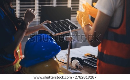 Two technicians inspect server racks in data center with tablet and fiber optic cable. Engineer and specialist discuss maintenance work in data center. Man and woman work together with safety equipmen