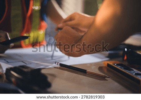 Two technicians inspect server racks in data center with tablet and fiber optic cable. Engineer and specialist discuss maintenance work in data center. Man and woman work together with safety equipmen