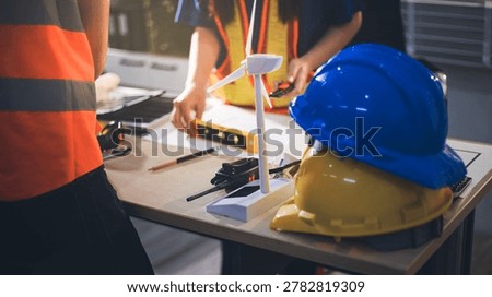 Two technicians inspect server racks in data center with tablet and fiber optic cable. Engineer and specialist discuss maintenance work in data center. Man and woman work together with safety equipmen