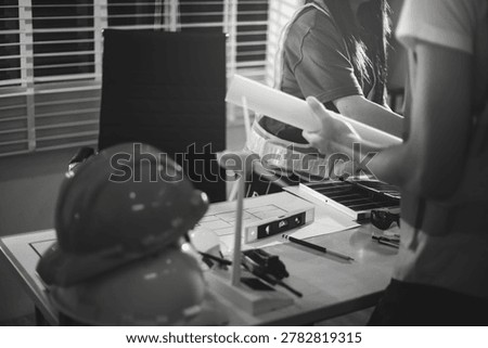 Two technicians inspect server racks in data center with tablet and fiber optic cable. Engineer and specialist discuss maintenance work in data center. Man and woman work together with safety equipmen