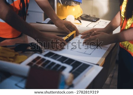 Two technicians inspect server racks in data center with tablet and fiber optic cable. Engineer and specialist discuss maintenance work in data center. Man and woman work together with safety equipmen