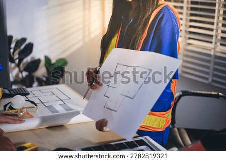 Two technicians inspect server racks in data center with tablet and fiber optic cable. Engineer and specialist discuss maintenance work in data center. Man and woman work together with safety equipmen