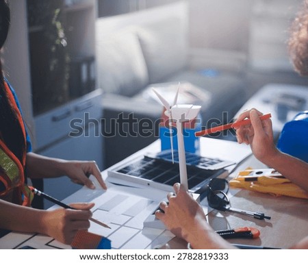 Two technicians inspect server racks in data center with tablet and fiber optic cable. Engineer and specialist discuss maintenance work in data center. Man and woman work together with safety equipmen