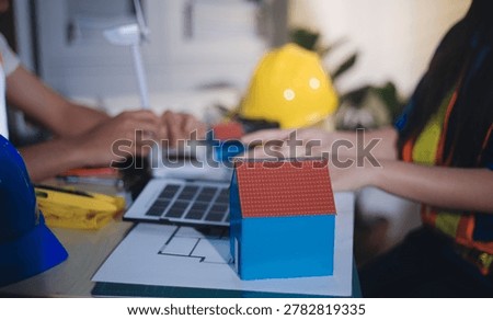 Two technicians inspect server racks in data center with tablet and fiber optic cable. Engineer and specialist discuss maintenance work in data center. Man and woman work together with safety equipmen