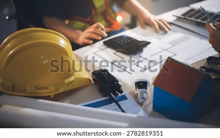 Two technicians inspect server racks in data center with tablet and fiber optic cable. Engineer and specialist discuss maintenance work in data center. Man and woman work together with safety equipmen