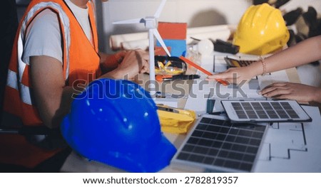 Two technicians inspect server racks in data center with tablet and fiber optic cable. Engineer and specialist discuss maintenance work in data center. Man and woman work together with safety equipmen