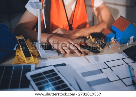 Two technicians inspect server racks in data center with tablet and fiber optic cable. Engineer and specialist discuss maintenance work in data center. Man and woman work together with safety equipmen