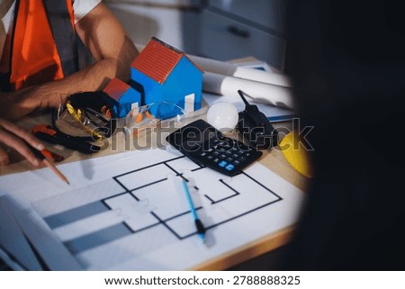 Two technicians inspect server racks in data center with tablet and fiber optic cable. Engineer and specialist discuss maintenance work in data center. Man and woman work together with safety equipmen