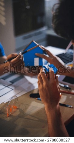 Two technicians inspect server racks in data center with tablet and fiber optic cable. Engineer and specialist discuss maintenance work in data center. Man and woman work together with safety equipmen