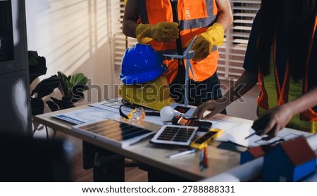 Two technicians inspect server racks in data center with tablet and fiber optic cable. Engineer and specialist discuss maintenance work in data center. Man and woman work together with safety equipmen