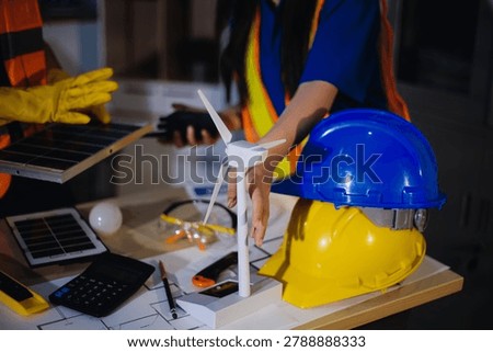 Two technicians inspect server racks in data center with tablet and fiber optic cable. Engineer and specialist discuss maintenance work in data center. Man and woman work together with safety equipmen