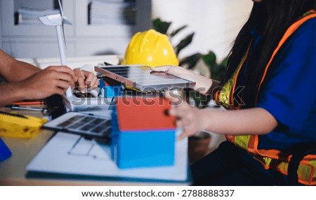 Two technicians inspect server racks in data center with tablet and fiber optic cable. Engineer and specialist discuss maintenance work in data center. Man and woman work together with safety equipmen