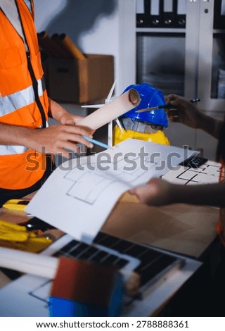 Two technicians inspect server racks in data center with tablet and fiber optic cable. Engineer and specialist discuss maintenance work in data center. Man and woman work together with safety equipmen