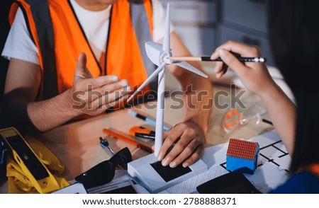 Two technicians inspect server racks in data center with tablet and fiber optic cable. Engineer and specialist discuss maintenance work in data center. Man and woman work together with safety equipmen