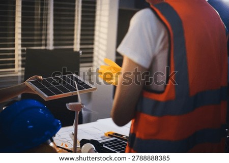 Two technicians inspect server racks in data center with tablet and fiber optic cable. Engineer and specialist discuss maintenance work in data center. Man and woman work together with safety equipmen