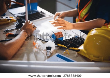 Two technicians inspect server racks in data center with tablet and fiber optic cable. Engineer and specialist discuss maintenance work in data center. Man and woman work together with safety equipmen