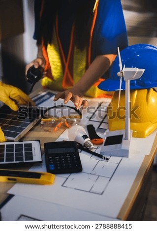 Two technicians inspect server racks in data center with tablet and fiber optic cable. Engineer and specialist discuss maintenance work in data center. Man and woman work together with safety equipmen
