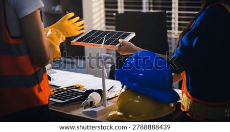Two technicians inspect server racks in data center with tablet and fiber optic cable. Engineer and specialist discuss maintenance work in data center. Man and woman work together with safety equipmen