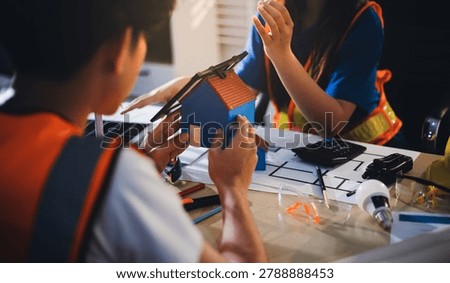 Two technicians inspect server racks in data center with tablet and fiber optic cable. Engineer and specialist discuss maintenance work in data center. Man and woman work together with safety equipmen