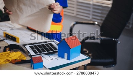 Two technicians inspect server racks in data center with tablet and fiber optic cable. Engineer and specialist discuss maintenance work in data center. Man and woman work together with safety equipmen