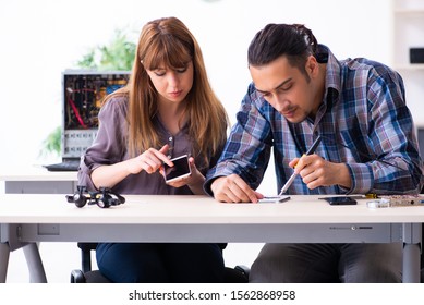 Two technicians working at computer warranty center