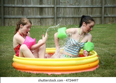 Two Teen Sisters Splashing In Kiddie Pool.