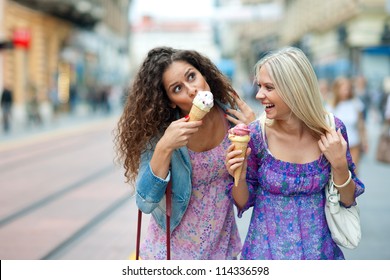 two teen woman friends having fun and eating ice cream