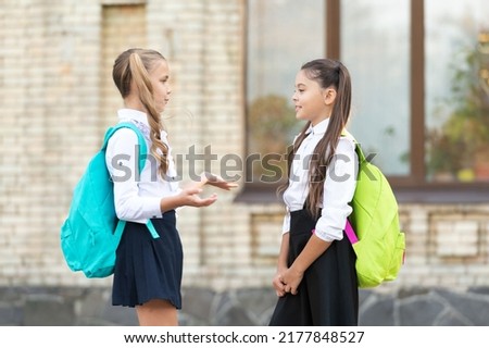 two teenage girls friends talking together outdoor