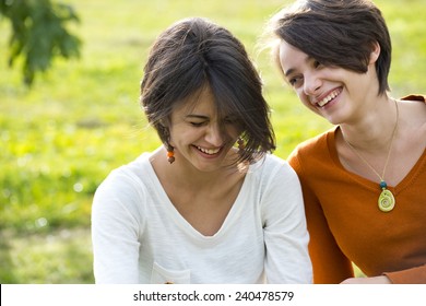 Two Teenage Girls Laughting Hard In Park