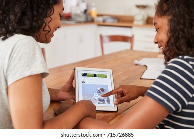 Two Teenage Girls Using Social Media On Digital Tablet