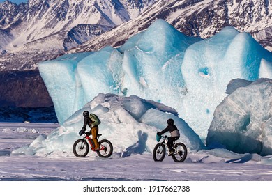 Two teenagers fat biking on Knik Glacier north of Anchorage, Alaska, USA