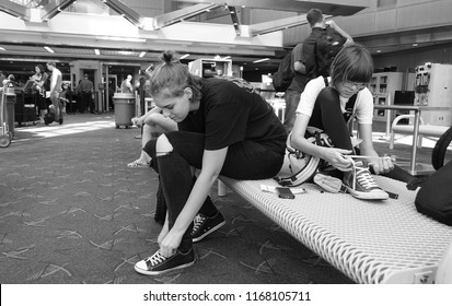 Two Teenagers Put Their Shoes Back On After TSA Airport Security Check                              