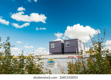 Two, temporary construction offices seen on a housing development site in the UK. The offices are staffed by architects and engineers for the housing development which is in progress.