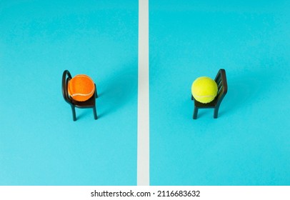 Two Tennis Balls Sitting On Chairs Opposite Each Other On Tennis Court. Minimal Concept.