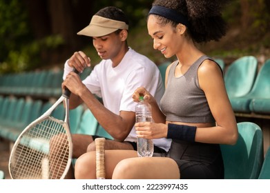 Two tennis players resting after the game and looking contented - Powered by Shutterstock